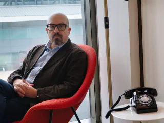 Balazs Fejes in a red armchair by the window, TWA Hotel at JFK airport